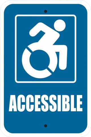 A blue sign with a white symbol of a person in a wheelchair moving forward.