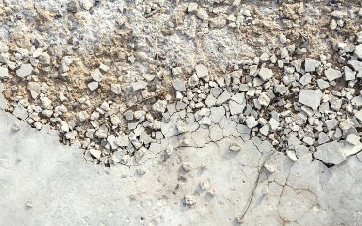 A photograph of concrete breaking into small pieces