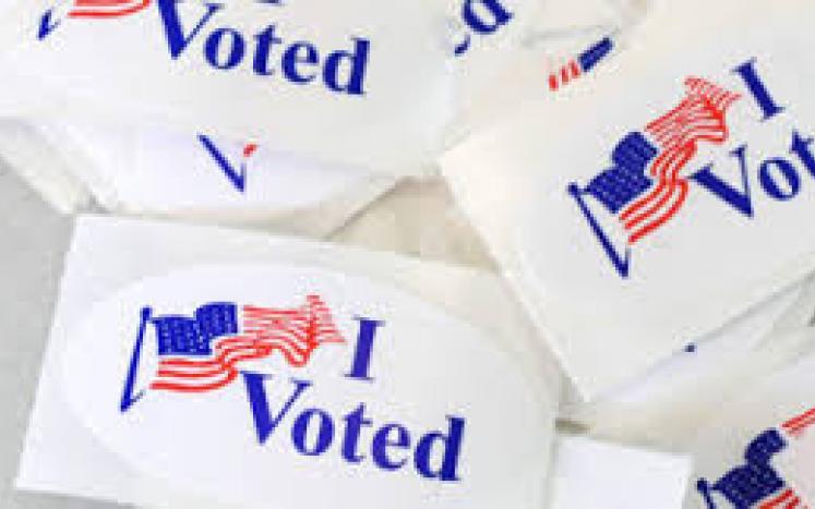 A photograph of lapel stickers that say "I voted" with an American flag.